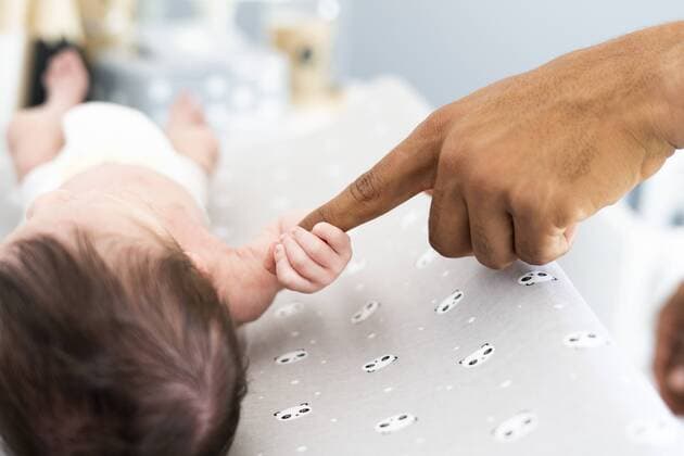 Close-up of newborn baby grabbing father s finger on changing table model released Symbolfoto property released  ERRF01297