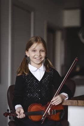 Portrait of a smiling girl with a violin at home model released Symbolfoto property released  EYAF00243