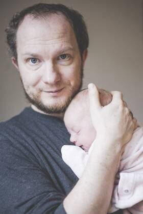 Portrait of father holding his sleeping newborn baby daughter model released Symbolfoto property released  IHF00010