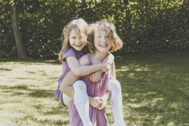 A big sister carrying her small sister, Girl power model released Symbolfoto  IHF00032