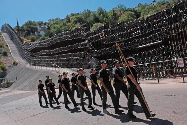 July 3, 2019 - Nogales, Arizona, US - 4th of July parade in Nogales, Arizona. The parade passes by the border wall between Mexico and Arizona that has been fortified with barbed wire by the US Army. Nogales US - ZUMAb411 20190703_zap_b411_038 Copyright: xChristopherxBrownx