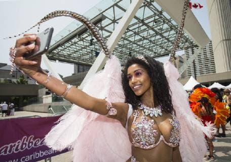(190709) -- TORONTO, July 9, 2019 -- A dressed-up reveler takes a selfie during the official launch ceremony of the 2019 Toronto Caribbean Carnival in Toronto, Canada, July 9, 2019. The annual four-week cultural festival of Caribbean music, cuisine and revelry kicked off on Tuesday. King and Queen costume competition, Junior Carnival, Grand Parade and other events will be held during the festival. ) CANADA-TORONTO-CARIBBEAN CARNIVAL-LAUNCH CEREMONY ZouxZheng 