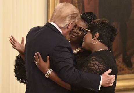 President Donald Trump embraces conservative commentators Diamond and Silk (Lynette Haradaway and Rochelle Richardson), during a Social Media Summit in the East Room of the White House, Washington, DC, Thursday, July 11, 2019. Trump brought together journalists, bloggers and internet executives to discuss the future of social media and its role in political reporting.  WAP20190711510 MIKExTHEILER
