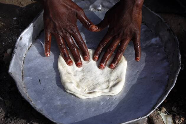 (190722) -- SANAA, July 22, 2019 (Xinhua) -- A Yemeni internally displaced mother prepares food at her shelter in al-Azraqin camp in the outskirts of Sanaa, Yemen, on July 22, 2019. Yemen has been mired into a civil war since late 2014 when Shiite Houthi rebels overran much of the country and seized all northern provinces, including the capital Sanaa. The civil war has killed more than 10,000 people, mostly civilians, displaced 3 million others, and pushed Yemen to the brink of famine. (Xinhua Mohammed Mohammed) YEMEN-SANAA-DISPLACED PEOPLE 