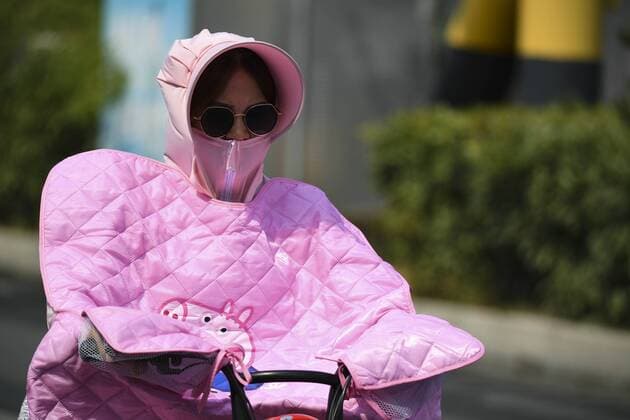 News Themen der Woche KW30 News Bilder des Tages BOZHOU, CHINA - JULY 22: A citizen wearing a hat, a facemask and a blanket rides amid heat one day ahead of Major Heat on July 22, 2019 in Bozhou, Anhui Province of China. Major Heat, the 12th solar term of the year, will begin on July 23 this year. The recent temperature in Bozhou soared above 35 degrees Celsius.  Copyright: xVCGx CFP111226378434