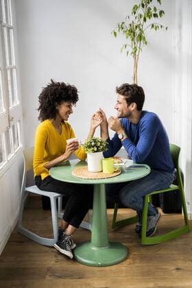 Happy affectionate couple sitting at table at home model released Symbolfoto property released  GIOF06447