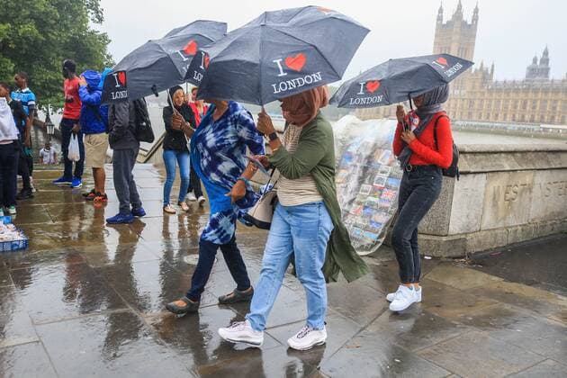 July 30, 2019, London, United Kingdom: Tourists on Westminster Bridge with souvenir umbrellas during rain showers as a month s rainfall was expected in three hours with the risk of flooding in some areas of the United Kingdom. London United Kingdom - ZUMAs197 20190730_zab_s197_004 Copyright: xAmerxGhazzalx
