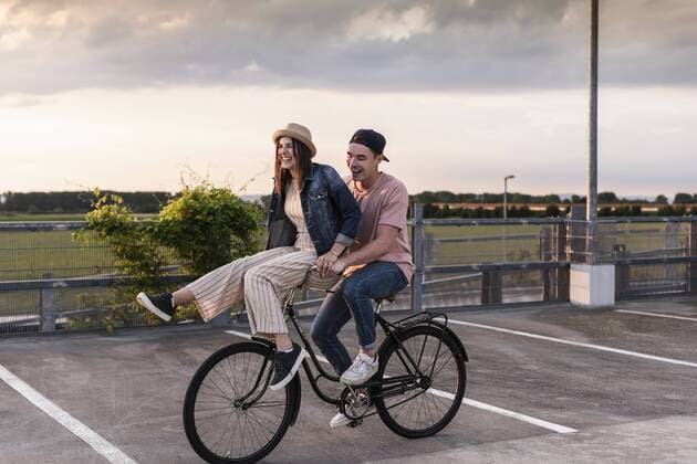Happy young couple together on a bicycle on parking deck model released Symbolfoto  UUF17971