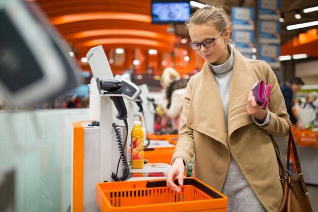  Pretty, young woman shopping for some fruit and smoothie in a grocery store paying for the goods at the self-service register (color toned image) ,model released, Symbolfoto  Copyright: xLightpoetx Panthermedia20228749