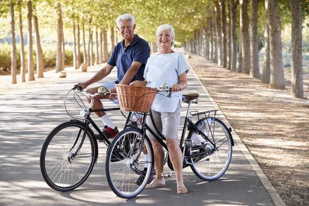  Portrait Of Smiling Senior Couple Cycling On Country Road ,model released, Symbolfoto,property released  Copyright: xMonkeybusinessx Panthermedia25729290