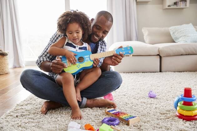 Toddler daughter sits on dadï¾s knee playing ukulele at home ,model released, Symbolfoto,property released  Copyright: xMonkeybusinessx Panthermedia25729563