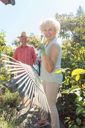  Cheerful senior woman holding a leaf rake during work in the garden ,model released, Symbolfoto  Copyright: xKzenonx Panthermedia25862948