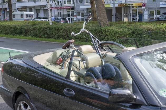 Bicycle lies on the back seat of a convertible in Berlin snapshot photography R Price