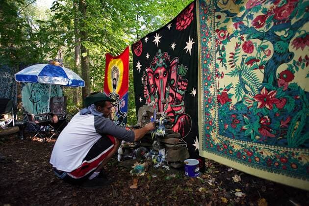 A man lights a candle at his camp site at the Yasgur Road Reunion celebrating the 50th anniversary of the Woodstock Music Festival at Yasgur Farm on Friday, August 16, 2019 in Bethel, New York. Woodstock was a music festival held August 15Ð18, 1969, which attracted an audience of more than 400,000 and is widely regarded as a pivotal moment in popular music history.  NYP20190816158 JOHNxANGELILLO