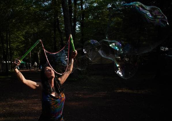 A woman makes giant bubbles in the camp site at the Yasgur Road Reunion celebrating the 50th anniversary of the Woodstock Music Festival at Yasgur Farm on Friday, August 16, 2019 in Bethel, New York. Woodstock was a music festival held August 15Ð18, 1969, which attracted an audience of more than 400,000 and is widely regarded as a pivotal moment in popular music history.  NYP20190816156 JOHNxANGELILLO