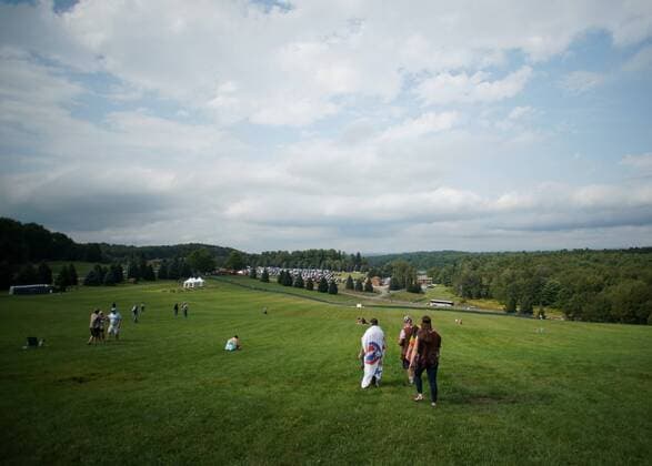 People walk down the hill and open field that is the location of the original concert at the 50th anniversary of the Woodstock Music Festival at Bethel Woods Center For The Arts on Friday, August 16, 2019 in Bethel, New York. Woodstock was a music festival held August 15Ð18, 1969, which attracted an audience of more than 400,000 and is widely regarded as a pivotal moment in popular music history.  NYP20190816125 JOHNxANGELILLO