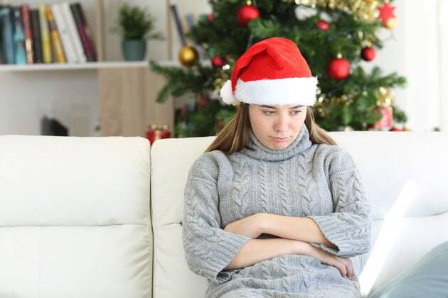  Sad teen sitting on a couch in christmas time at home ,model released, Symbolfoto  Copyright: xAntonioGuillemx Panthermedia26575124