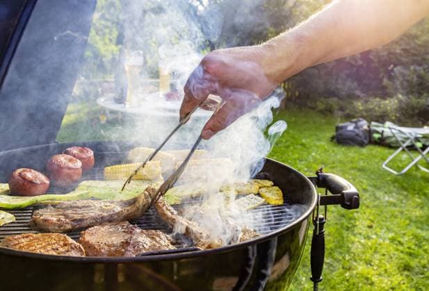DEU, Deutschland, Münsingen, Baden-Württemberg, 24.08.2019: Grillfest im Garten. Auf dem Rost liegen Steaks vom Rind, Lammkeule, Schweinenacken sowie Tomaten, Mais und Zucchini. *** DEU, Germany, Münsingen, Baden Württemberg, 24 08 2019 Barbecue in the garden Steaks of beef, leg of lamb, neck of pork, tomatoes, corn and courgettes lie on the grill