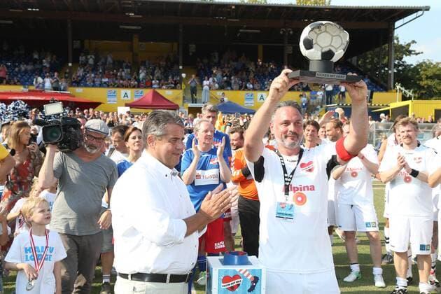 Hamburg Sigmar Gabriel hands over the winners trophy to childrens cardiologist Tom Mir from the Placebo Kickers Charity Football event Kicken mit Herz at the sports field SC Victoria Hoheluft Stadium in Hamburg on 25 8 2019