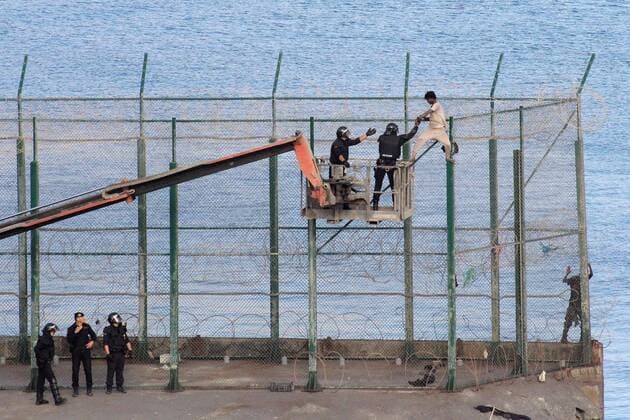 A migrant is detained by the police on a crane as he remained on top of the border fence on the wait to safely jump onto Spanish soil in Ceuta, Spanish enclave in the north of Africa, 30 August 2019. Over 150 migrants managed to enter in Spain from Morocco, in a mass breach of the border fence, in early morning. Over 150 migrants jump the fence in Ceuta !ACHTUNG: NUR REDAKTIONELLE NUTZUNG!  Copyright: xReduanxDrisxRegraguix GRAF3261 20190830-637027646303971304