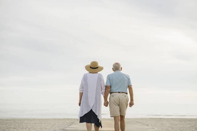 Creative Highlights Symbolfotos Back view of senior couple standing hand in hand on wooden boardwalk looking to the sea, Liepaja, Latvia model released Symbolfoto  AHSF00710