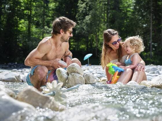 Family with daughter playing in a mountain stream model released Symbolfoto  CVF01367