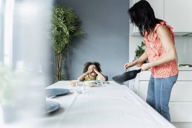 Mother serving meal for daughter sitting at dining table model released Symbolfoto property released  ERRF01714