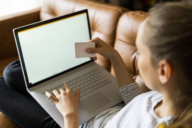 Young woman on couch at home shopping online model released Symbolfoto property released  GIOF06723