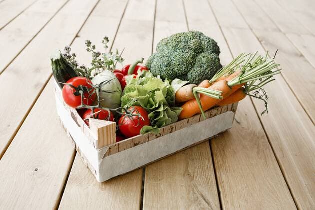 Wooden box of organic vegetables on wooden floor  KMKF01018