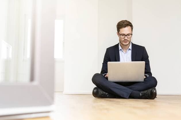 Businessman sitting on the floor using laptop model released Symbolfoto property released  PESF01691