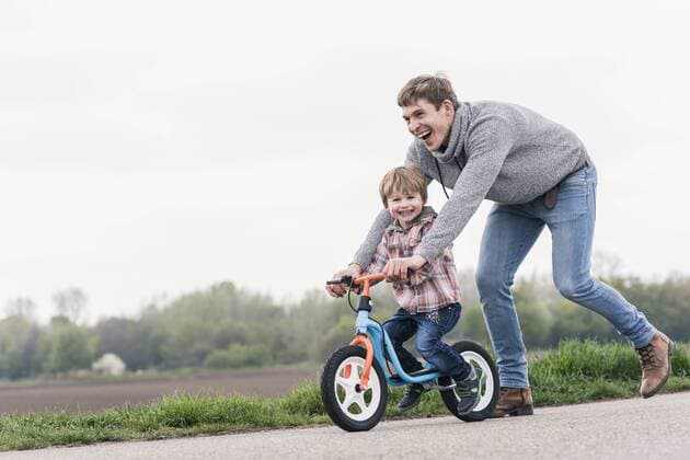 Father teaching his son how to ride a bicycle, outdoors model released Symbolfoto  UUF17991