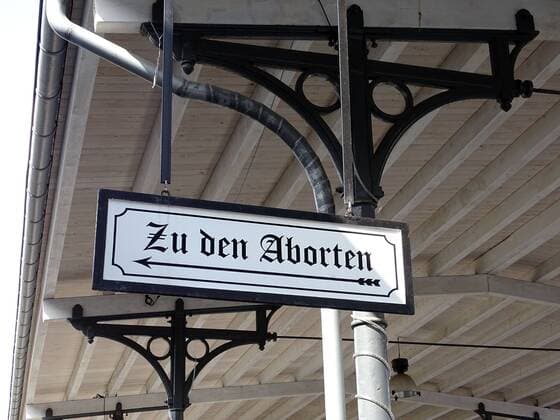 Zu den Aborten - Vor dem Antritt der Bahnfahrt konnte sich jeder Reisende nochmals erleichtern - in den Aborten (Toiletten). Historischer Bahnsteig mit Hinweisschild *** To the abortions Before the start of the train journey, every traveller could make themselves easier once again in the abortions Toilets Historical platform with information sign