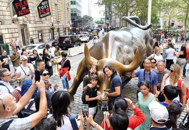 (190909) -- NEW YORK, Sept. 9, 2019 -- Tourists pose for photos near the damaged Wall Street Charging Bull in New York, the United States, on Sept. 9, 2019. A man was arrested on Sept. 7 for damaging the iconic Wall Street Charging Bull statue in New York with an object resembling a banjo, local media reported. ) U.S.-NEW YORK-CHARGING BULL-DAMAGE LixRui 