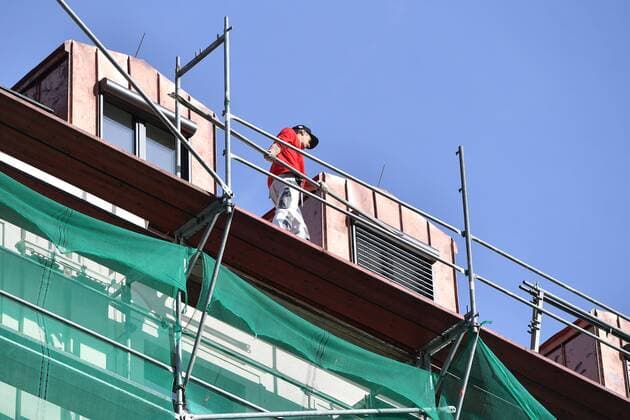 Bauarbeiter geht auf einem Geruest eins Hauses. Sanierung,Renovierung eines Altbaus,Haus Altbau,Altbauwohnung,Immobiiie, Metropole,Immobilienpreise,Immobilien,Stadtmitte,Zentrum,Fassaden,Fassade,Gebaeude,Haeuser,Lage,Stadtlage,Innenstadt,Stadtzentrum, Stadtansicht. *** Construction worker walks on a scaffold one house renovation,renovation of an old building,house old building,old building apartment,Immobiiie, metropolis,property prices,real estate,city center,center,facades,facade,buildings,houses,location,city location,downtown,city center, city view