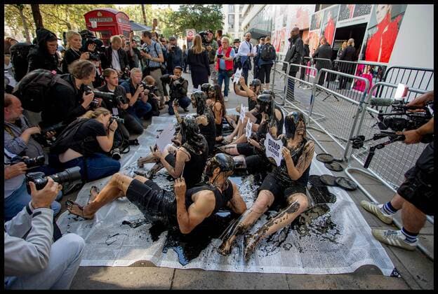 . 13 09 2019. London, United Kingdom. PETA Leather protest at London Fashion Week. PETA supporters pour buckets of black toxic slime over their heads at London Fashion Week to draw attention to the hazardous waste associated with the leather industry. Signs on the buckets read, Leather Is a Dirty Business and Dump Leather .  xMartynxWheatleyx xi-Imagesx IIM-20145-0021