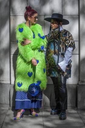 Street Style on day two of London Fashion Week SS 2020 on Friday September 13th 2019, showcasing stylish individuals London is internationally known for. Image shows fashion writer Saffy Khan from London. She wears a feux fur coat and bag by Starsica with shoes by Nine West, plus vintage sunglasses and shoes. Image also shows celebrity stylish Sanjay from London. he wears a top from Marques Almeida, with a vintage shirt, a hat, trousers from Zara with Dr.Martens shoes and a bag by Balenciaga.  (112044835)
