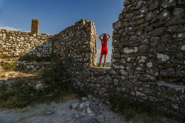 Eine Frau mit einem roten Kleid steht auf einer Mauer der Burg Rozafa (Kalaja e RozafÃ«s). Shkodra (ShkodÃ«r), Albanien. Mit dem Campingbus unterwegs in Albanien *** A woman with a red dress is standing on a wall of the castle Rozafa Kalaja e RozafÃ s Shkodra ShkodÃ r , Albania Travelling in Albania with a camping bus