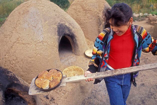 IMAGO Cultures of the world, Taos Pueblo in New Mexico, USA Native American Child - Taos Pueblo. New Mexico USA - Child cooking bread. Model released.  Copyright: JohnxCancalosi 10735866