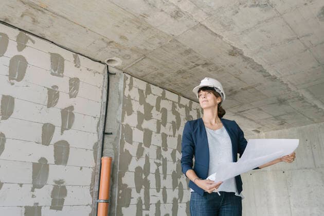 Female architect checking architectural plan on construction site model released Symbolfoto property released  AHSF00846