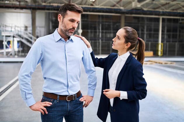 Businesswoman talking to disappointed businessman in a factory model released Symbolfoto property released  BSZF01255
