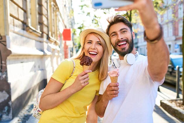 Happy young couple taking a selfie while eating ice cream in the city model released Symbolfoto  BSZF01369