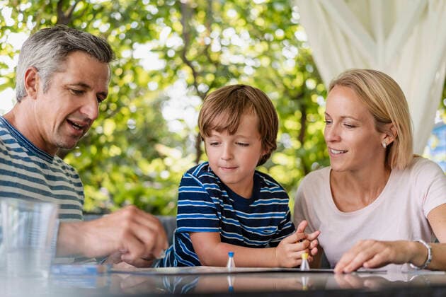 Happy parents and son playing a board game on terrace model released Symbolfoto property released  DIGF08138