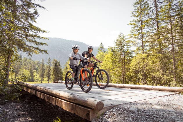 Mother and daughter riding e-mountain bikes in the mountains model released Symbolfoto  FKF03532