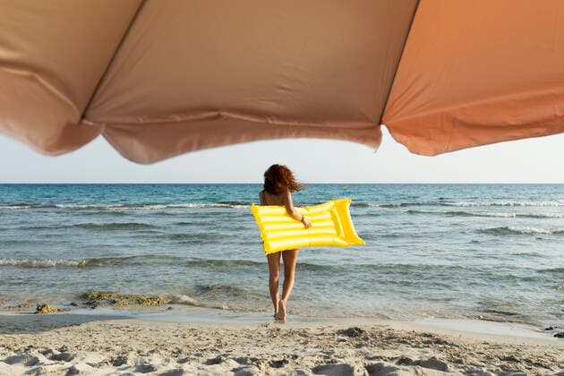 Young woman with yellow airbed at the beach model released Symbolfoto  JPTF00257