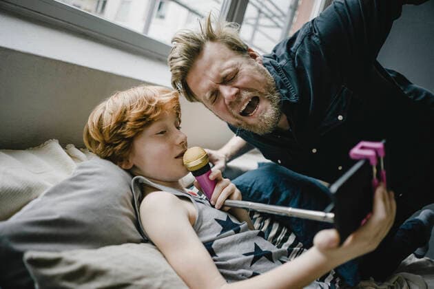 Father and son with smartphone and microphone at home model released Symbolfoto property released  KNSF06239