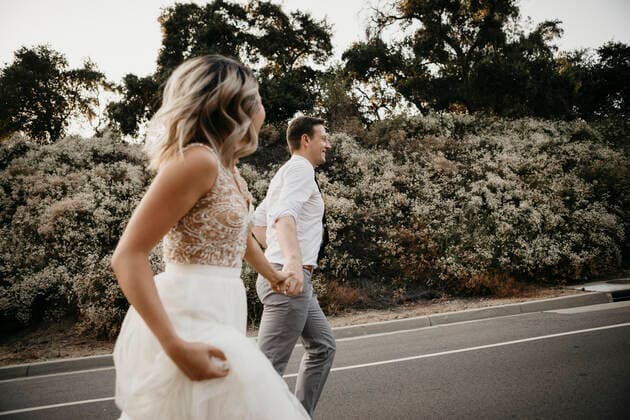 Bride and groom walking hand in hand on a country road model released Symbolfoto  LHPF00754