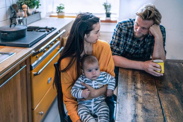 Serious family with baby sitting at kitchen table at home model released Symbolfoto property released  RIBF01068