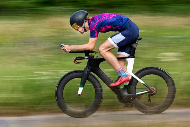 Triathlete riding bicycle on country road, Germany model released Symbolfoto  STSF02136