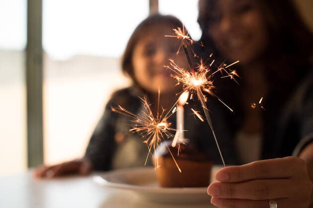 Mother and daughter celebrating birthday with cupcake and sparklers,model released, Symbolfoto ING_37293_03702