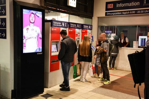 passengers at the ticket vending machine at the train station zoo passengers at the ticket vending machine at the train station zoo